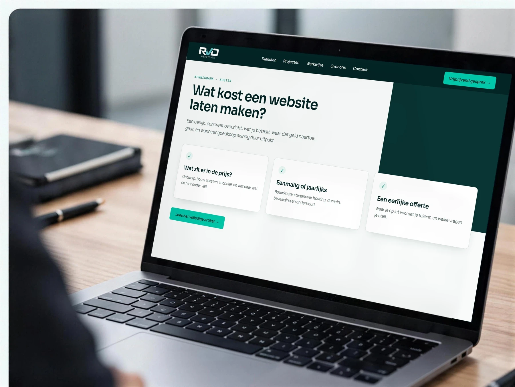 Laptop op een bureau met een pagina over de kosten van een website en drie informatiepanelen in beeld
